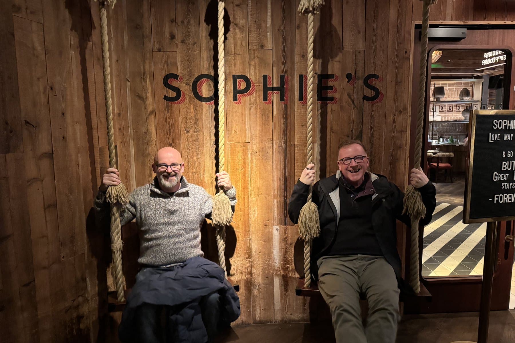 Hunter Samuels and John Shepard laughing side by side on rope swings.